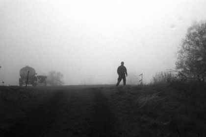 A man standing on a field in the fog