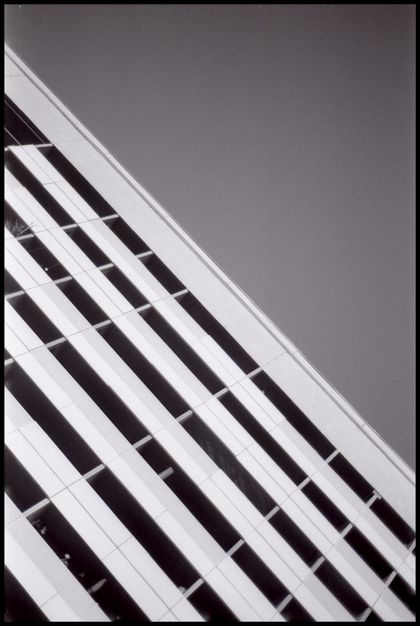 A prefab living quarter, as seen from a frog perspective. Its lines are straightened and flow from the top left to the botom right section of the image. The top right half is grey sky.